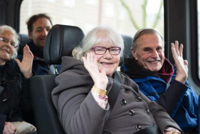 Ouderen zwaaien vanuit de PlusBus