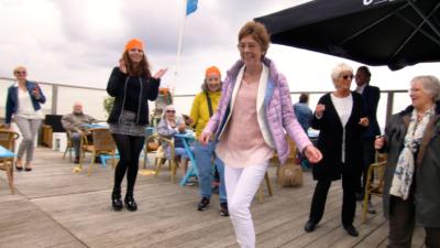 Klanten die dansje maken op terras tijdens lunch met Axxicom Thuishulp Klanten die dansje maken op terras tijdens lunch met Axxicom Thuishulp