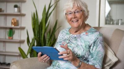 Een vrouw kijkt naar haar ipad