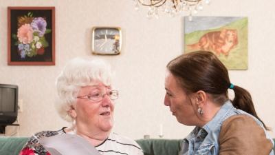 Thuishulp en client praten bij op de bank